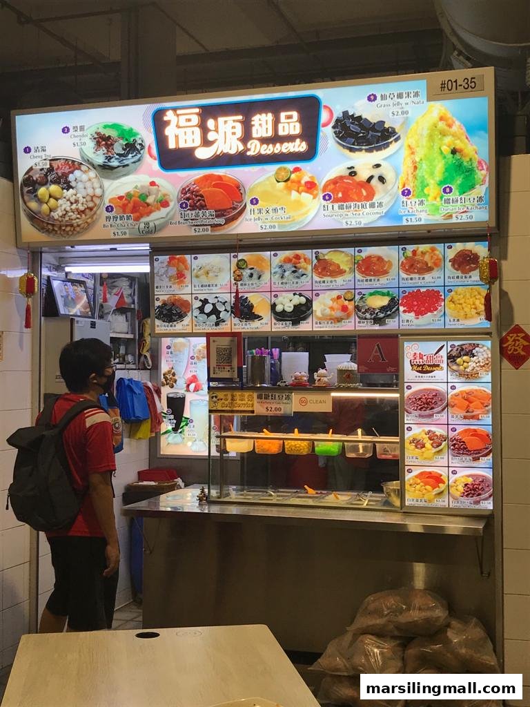 A customer views the vibrant menu and ingredients at Hock Guan Desserts, a bustling dessert stall.