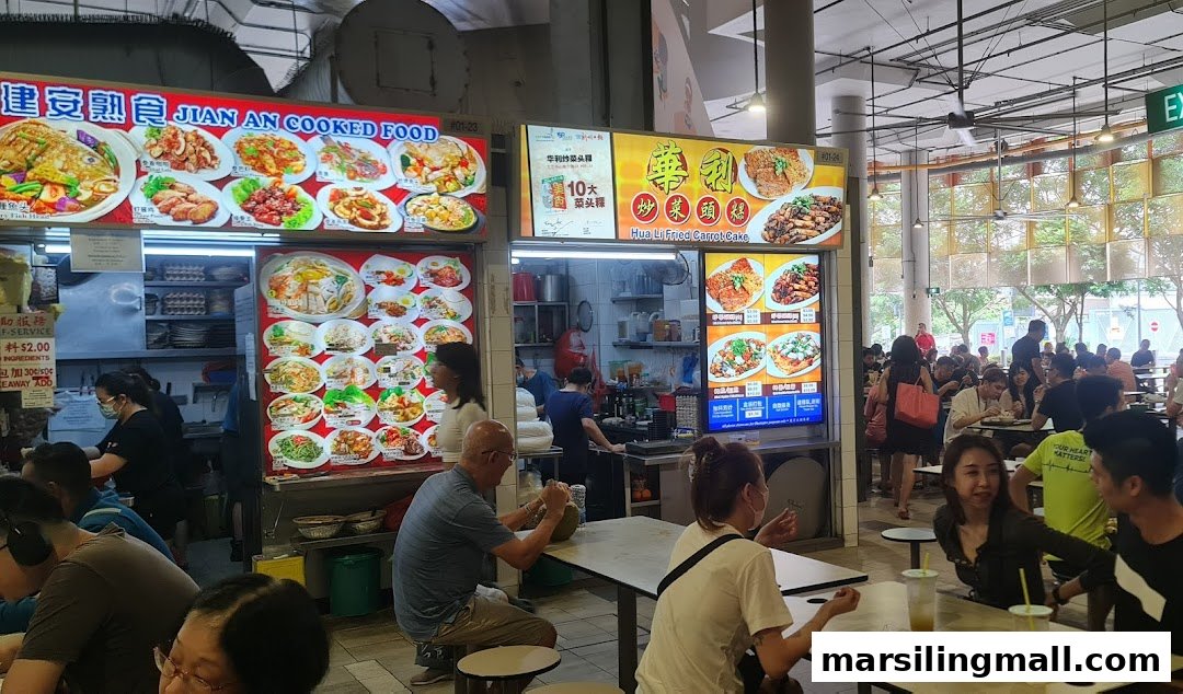 A bustling food court scene featuring multiple food stalls, including Hua Li Fried Carrot Cake, with many patrons dining.