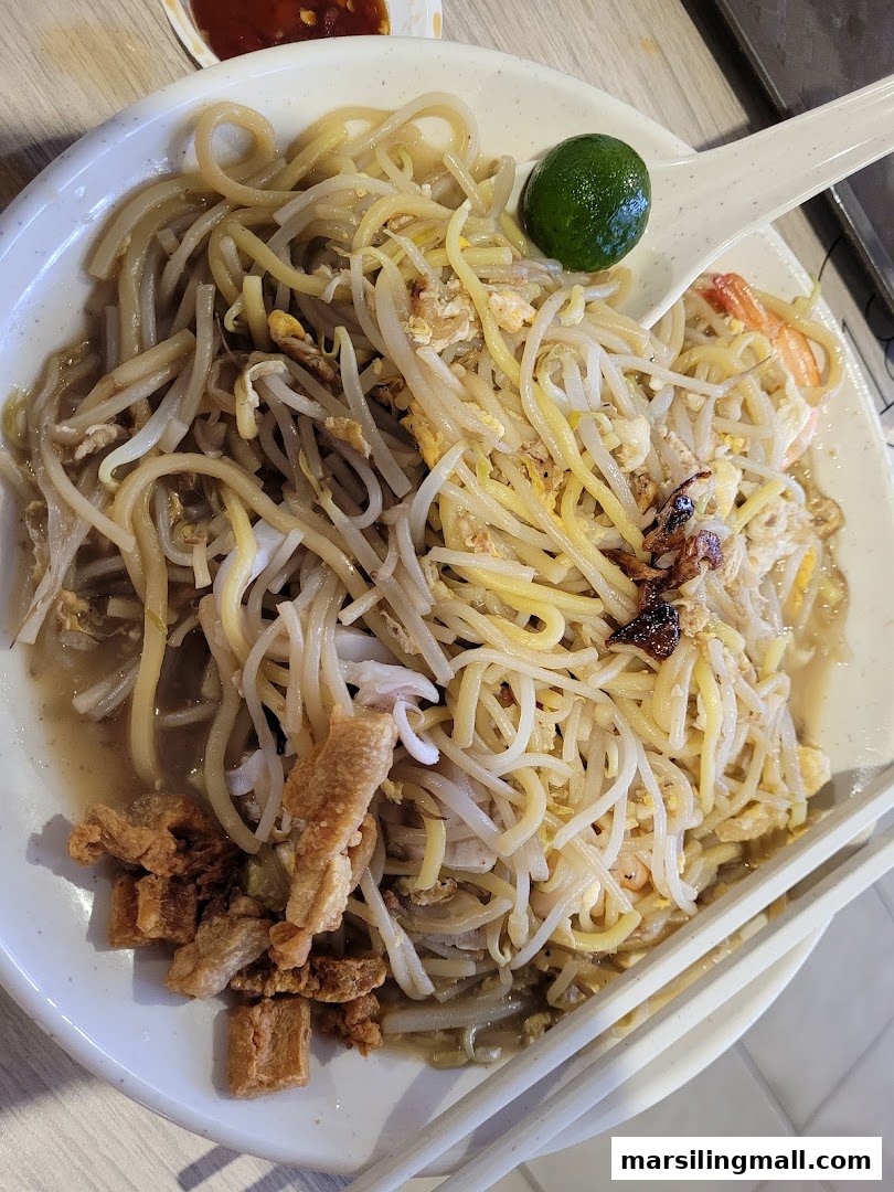 A close-up of a delicious bowl of stir-fried noodles with seafood, bean sprouts, and crispy pork lard.