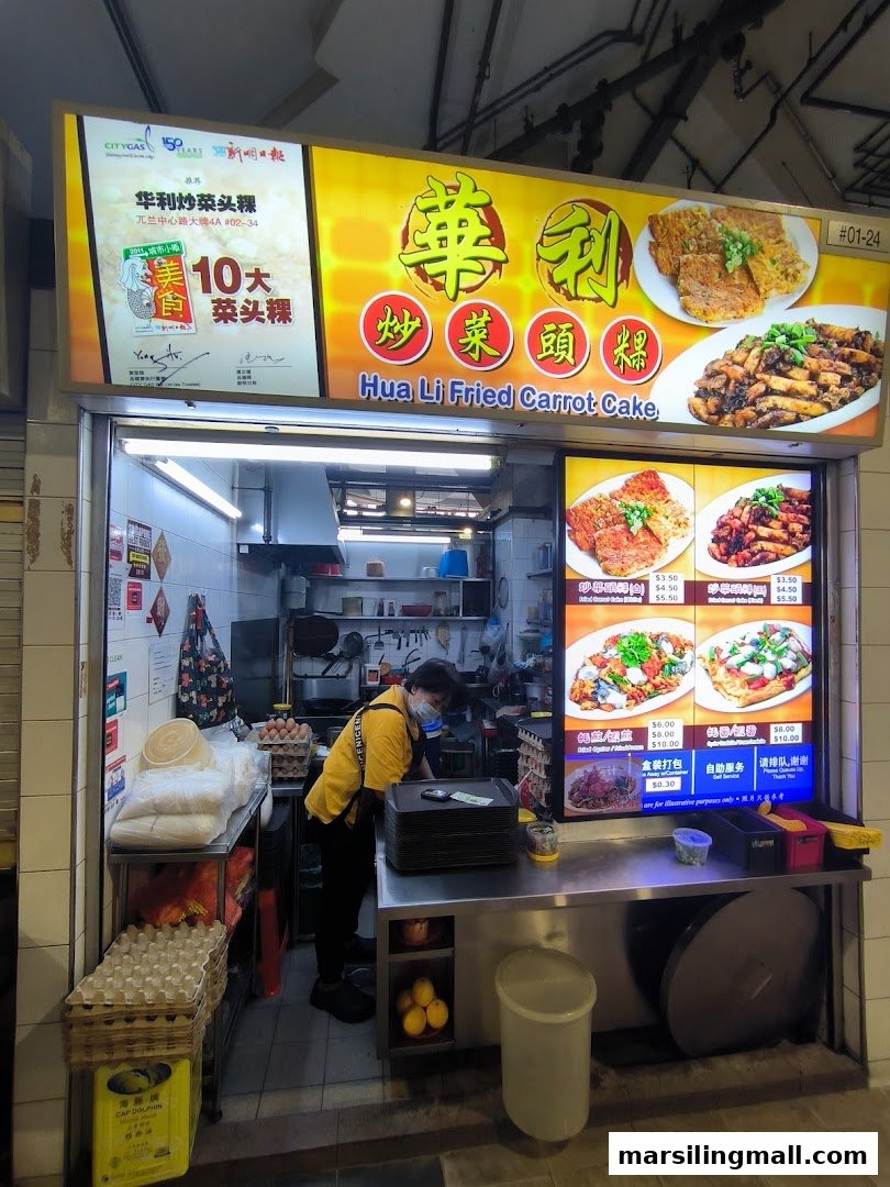 The storefront of Hua Li Fried Carrot Cake, a hawker stall, with a staff member preparing food.