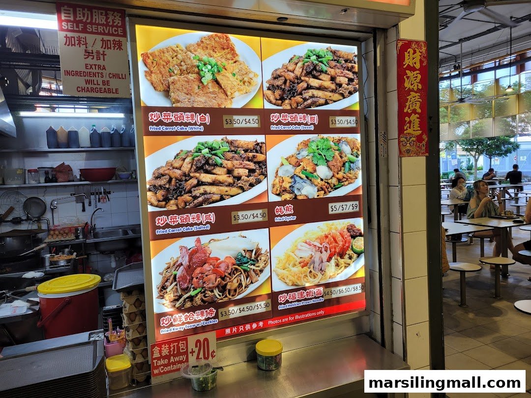 A brightly lit menu board showcasing various local dishes with prices at Hua Li Fried Carrot Cake.