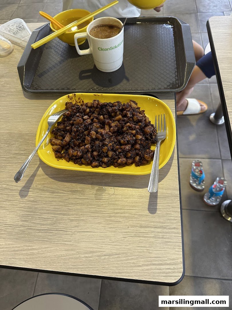 A plate of dark fried carrot cake and a cup of coffee on a wooden table.