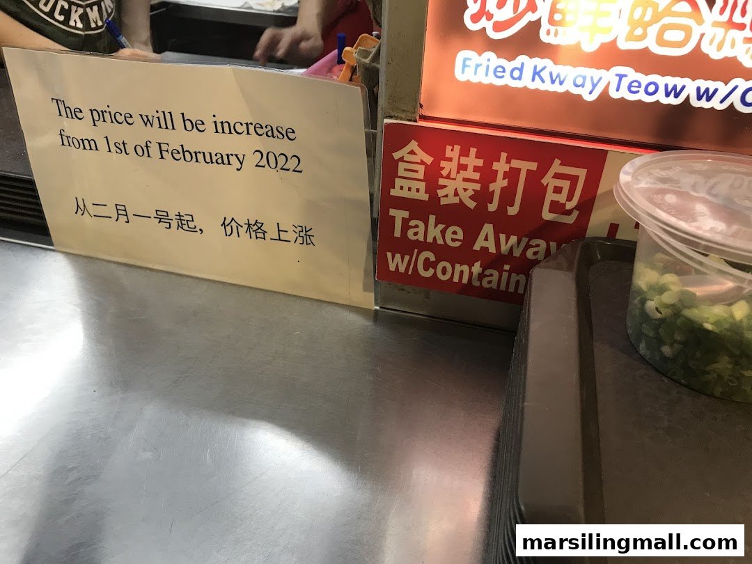 A counter with a price increase notice and a 'Take Away' sign at a food stall.