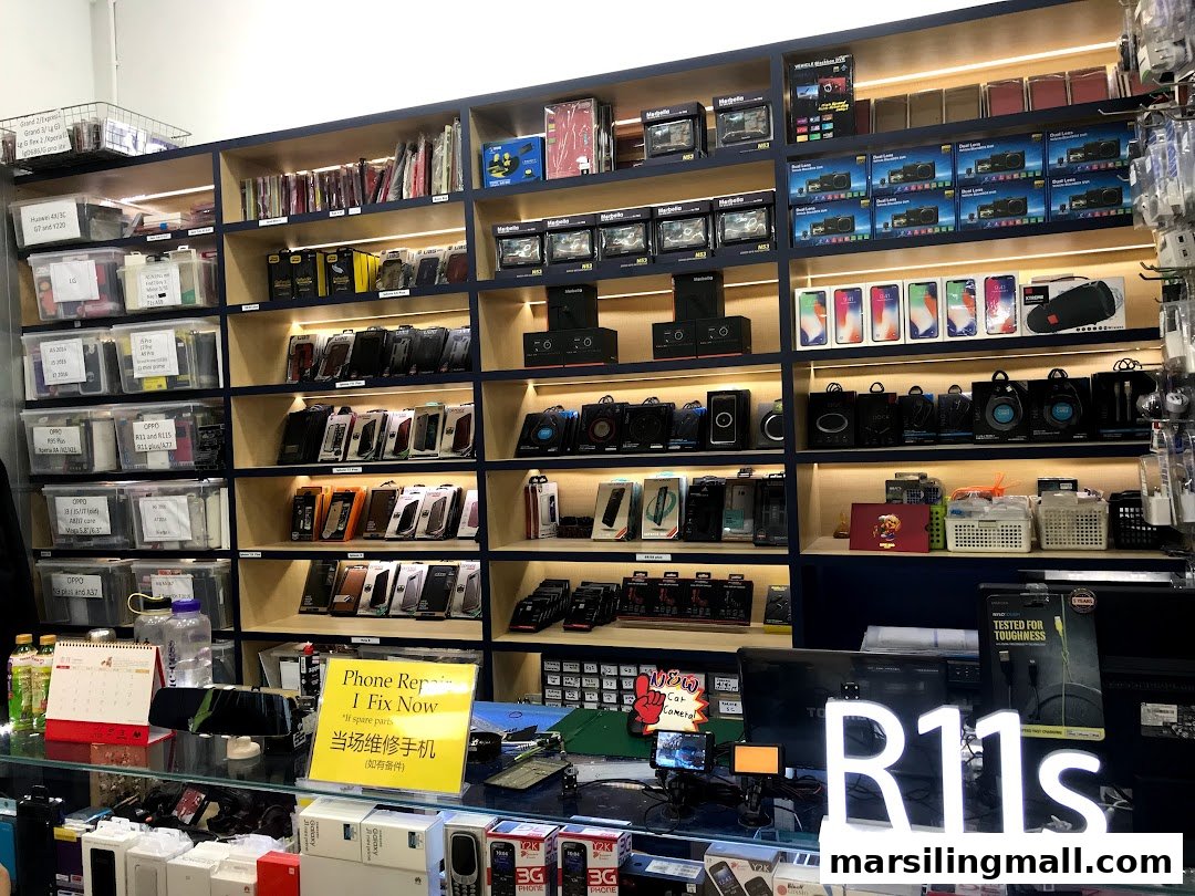 An interior view of ImobileHub, showcasing shelves filled with mobile phone accessories, cases, and a phone repair service sign.