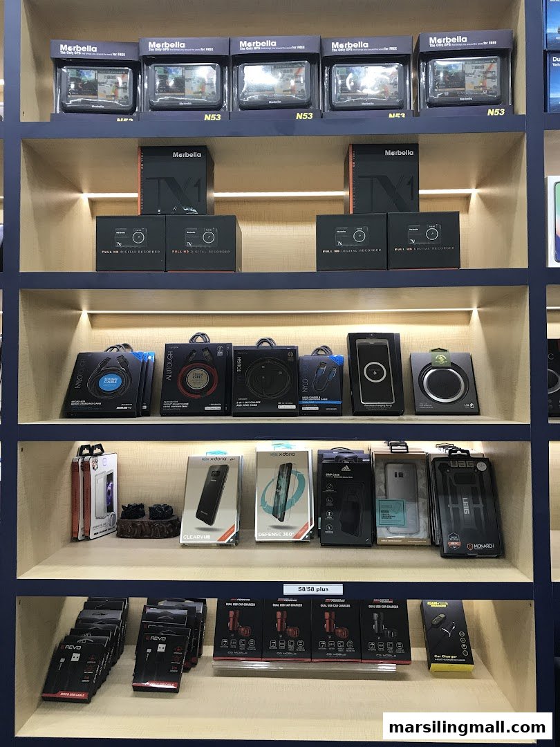 A well-lit display shelf showcasing a variety of mobile accessories, car chargers, and digital recorders.