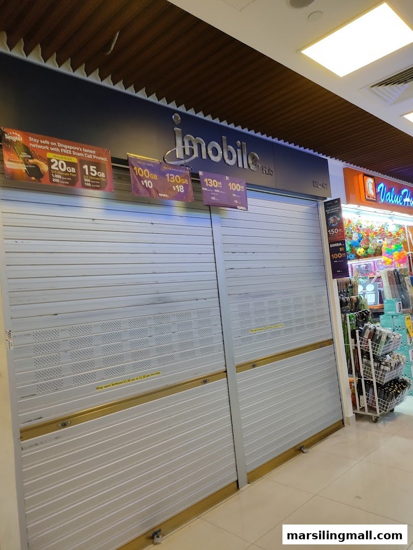 The closed storefront of ImobileHub, featuring advertisements for mobile data plans from Singtel and SIMBA.