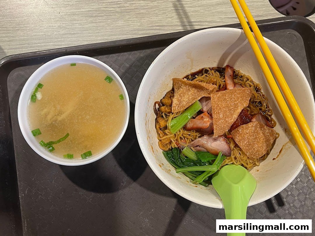 A delicious bowl of char siu wanton noodles with crispy wonton skin and a side of clear soup.