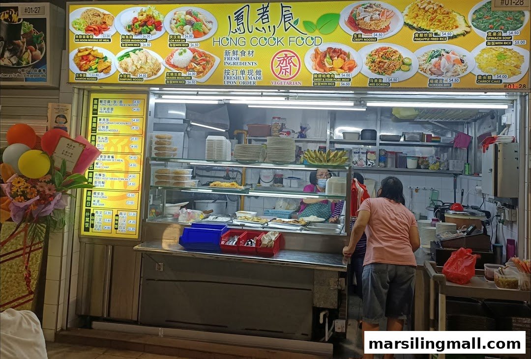 A bustling food stall named Jian An Cooked Food with a vibrant menu board and staff.