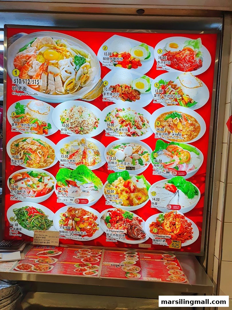 A brightly lit menu board displaying various Asian dishes with photos and prices.