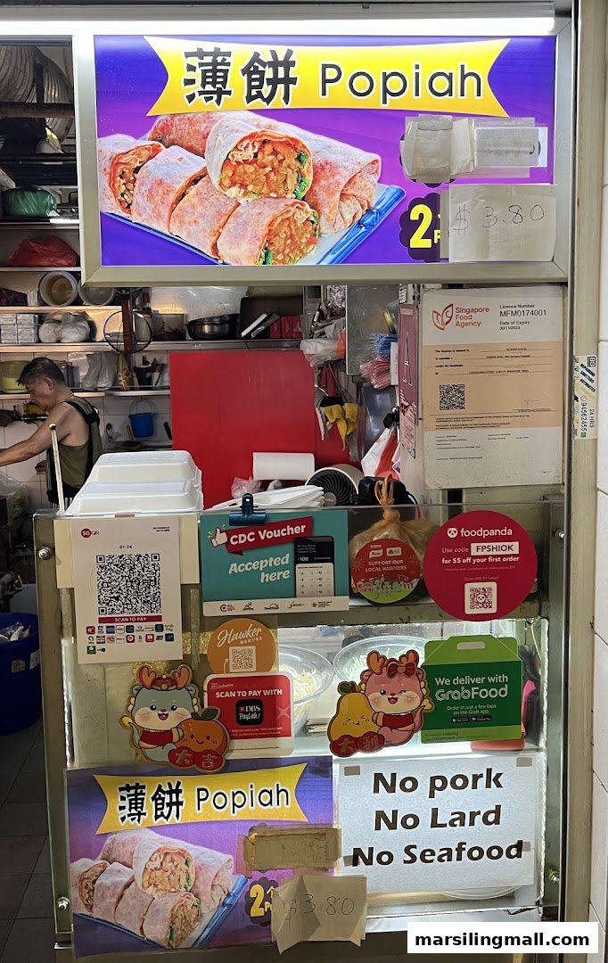 A food stall counter showcasing Popiah, payment options, and delivery services, with a hawker in the background.