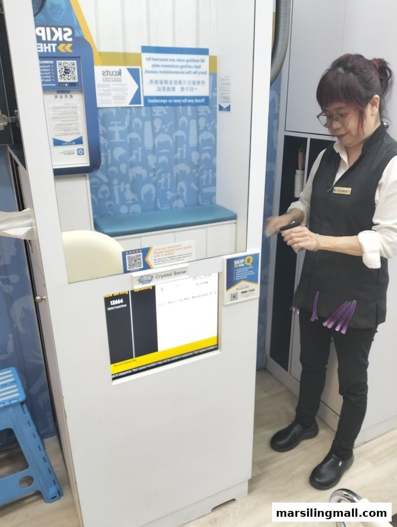 A staff member stands next to a queue management system in a hair salon.