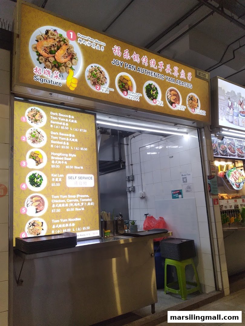 A brightly lit hawker stall, Joy Pan Authentic Yam Abacus, showcasing its signature dishes and menu.