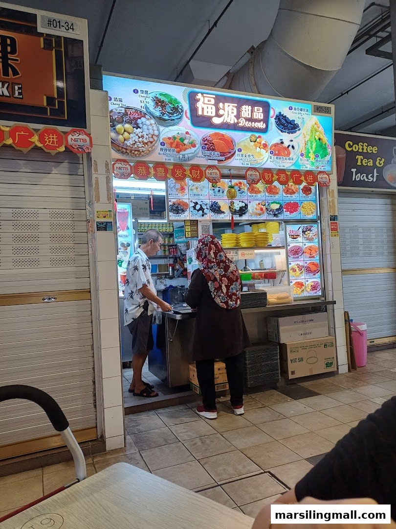A vibrant dessert stall named Fu Yuan Desserts in a hawker centre, serving customers.