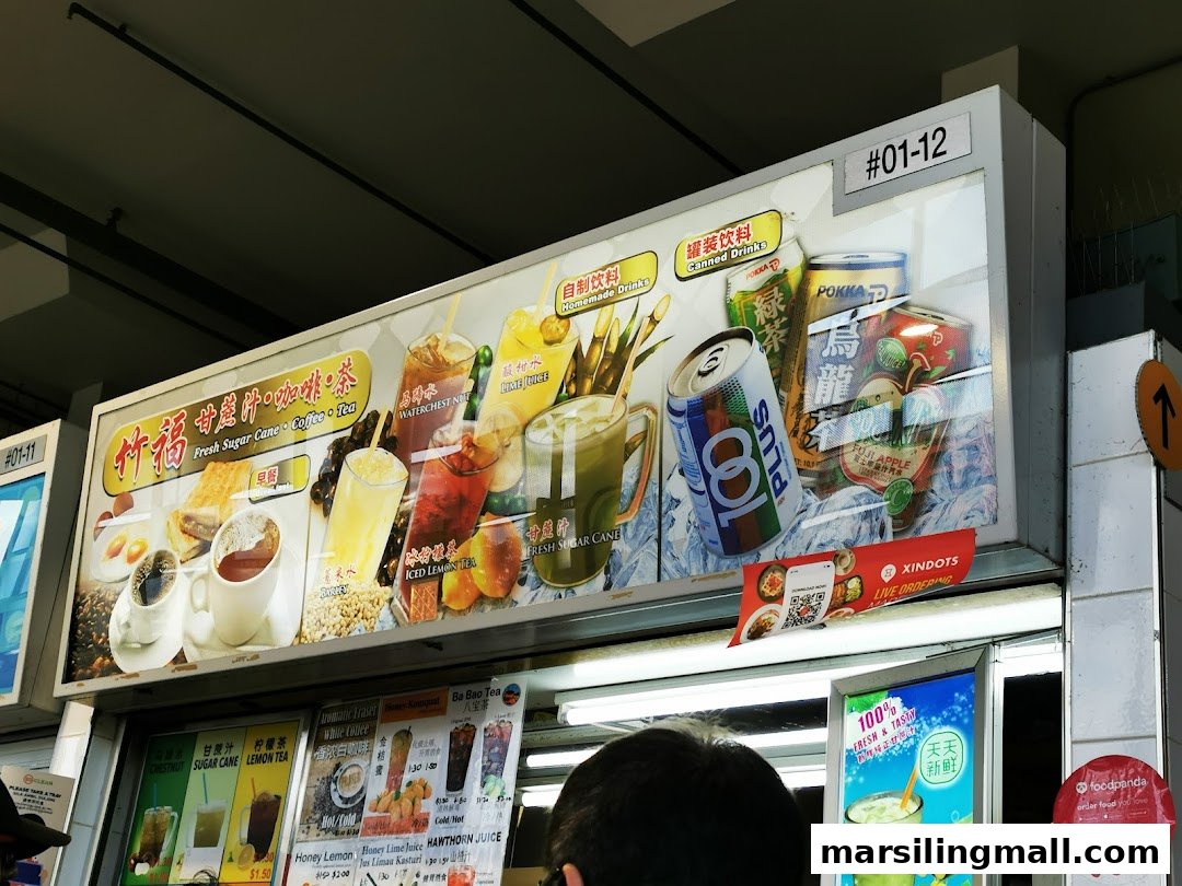An illuminated hawker stall display board showcasing a variety of refreshing drinks and some breakfast items.