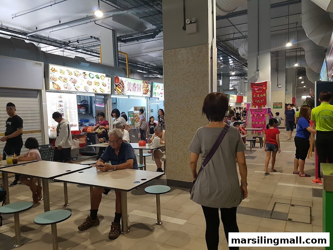 A bustling hawker centre interior with various food stalls and patrons dining.