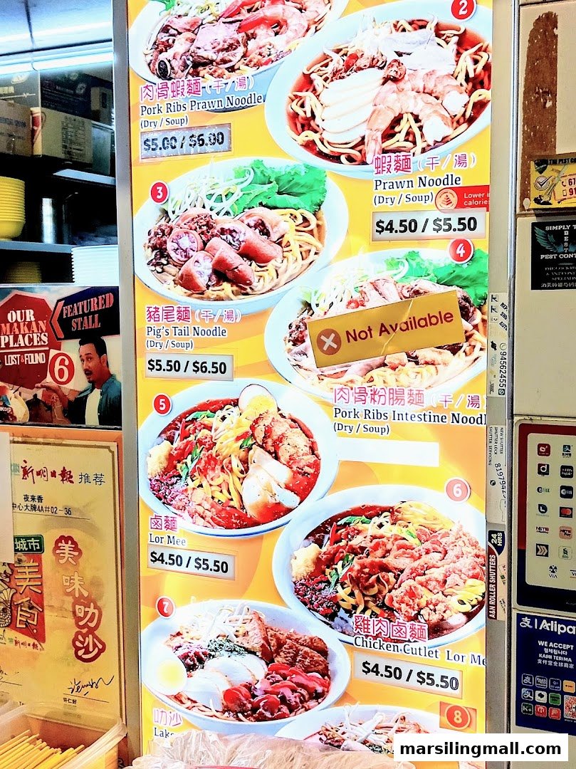 A brightly lit menu board displaying various noodle dishes with prices and images.