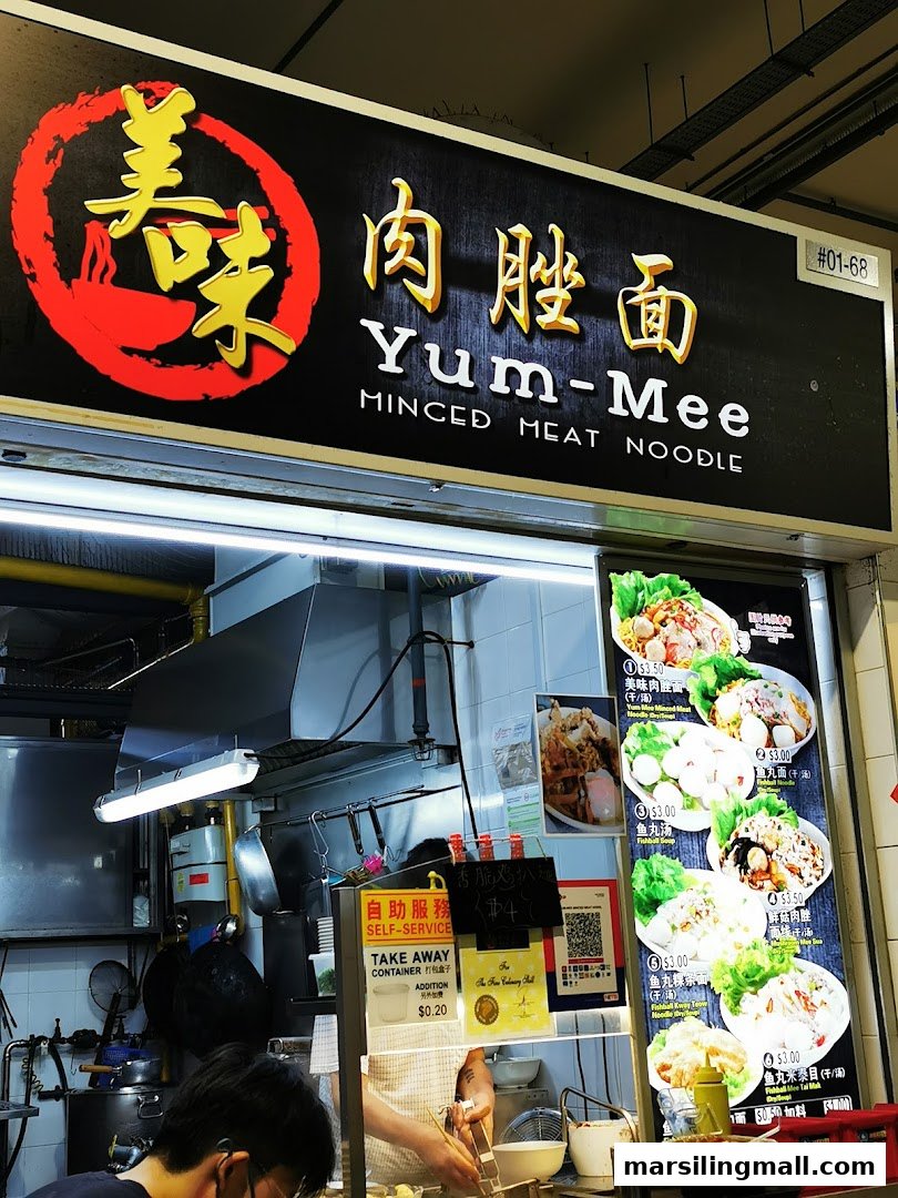 A vibrant hawker stall sign for Yum-Mee Minced Meat Noodle with a visible menu board.