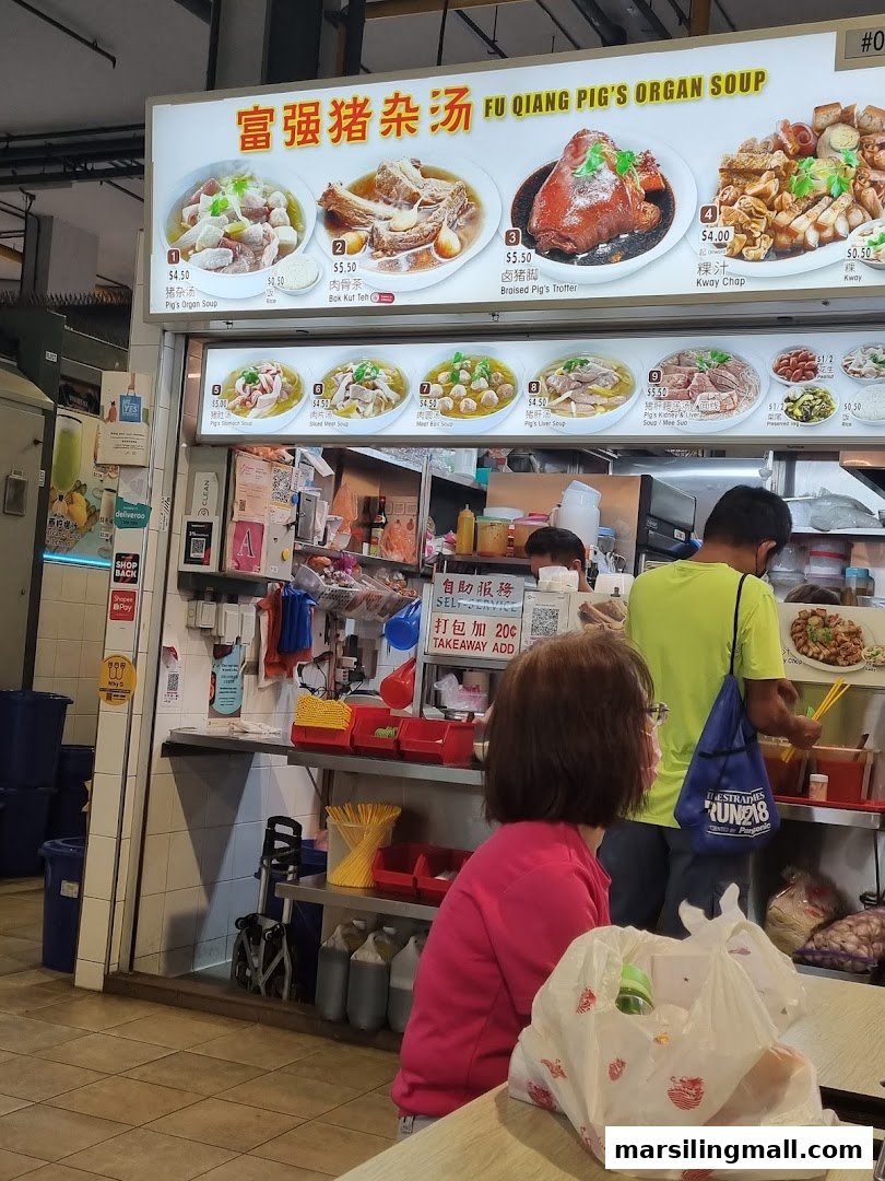 A hawker stall's menu board displaying various traditional Chinese dishes and their prices.