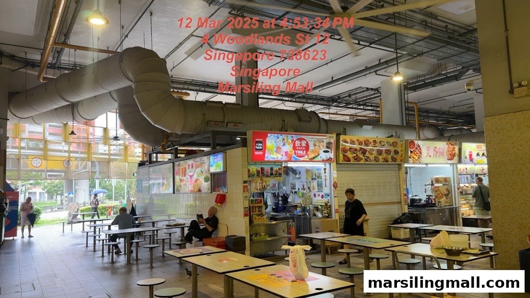 A bustling indoor hawker centre with various food stalls and dining areas.