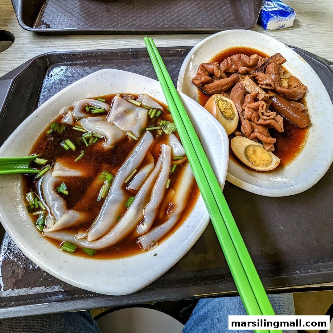 A close-up of two plates of delicious braised kway chap and offal with eggs, served on a tray.