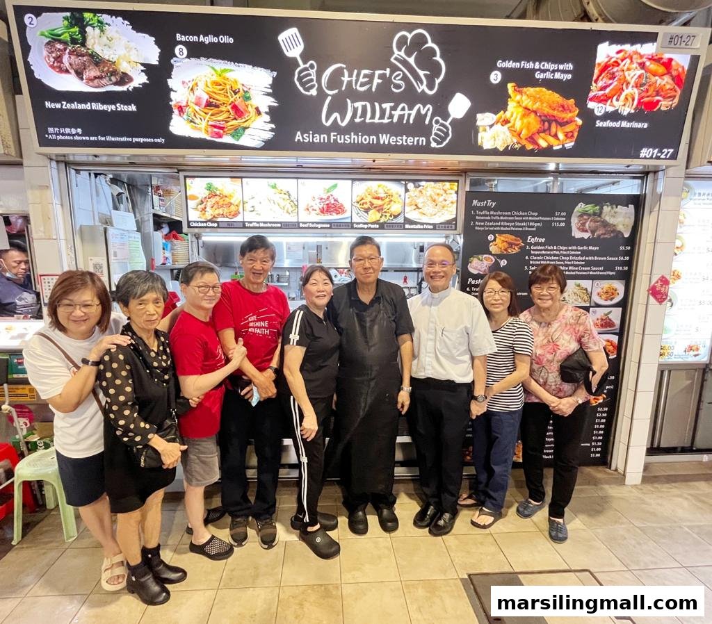 A group of people, including staff, pose in front of Chef's William Asian Fushion Western hawker stall.