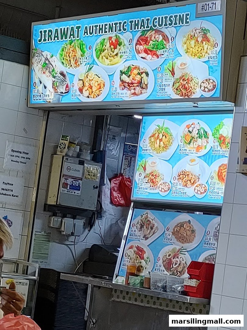 A brightly lit menu board displaying various authentic Thai dishes with prices and images.