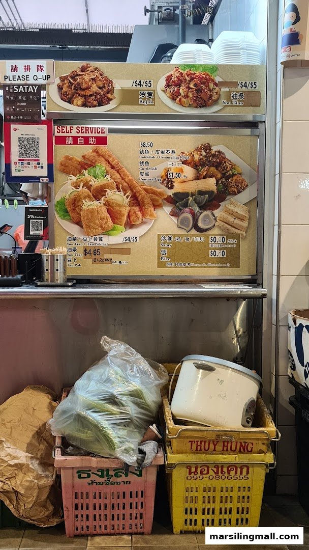 A hawker stall's menu board displaying various local dishes and prices.