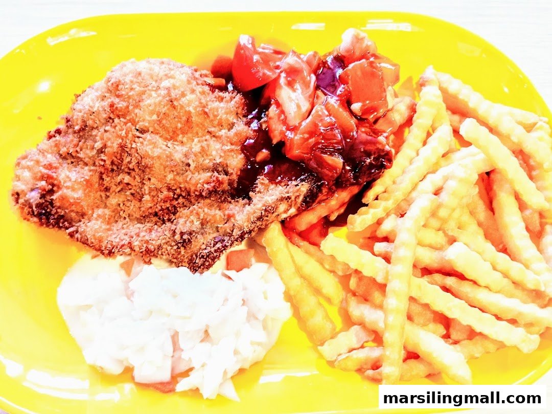 A crispy fried cutlet with crinkle-cut fries, coleslaw, and sauce on a bright yellow plate.