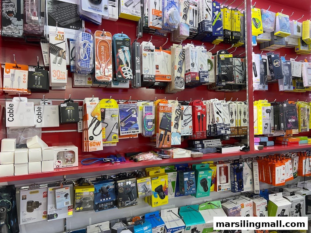 A retail display wall showcasing a wide variety of electronic accessories like cables, chargers, and phone holders.