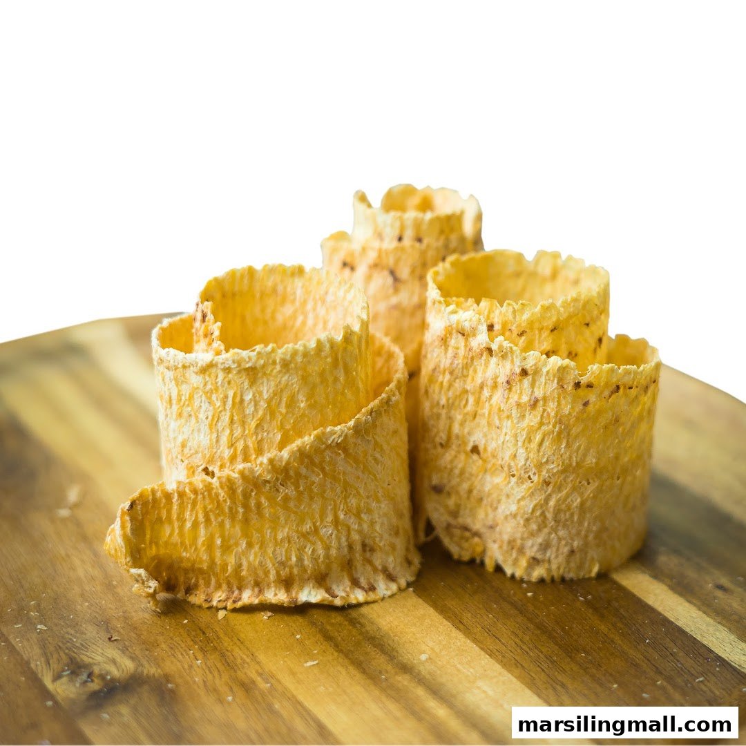 Close-up of several golden, crispy, rolled-up snacks on a wooden board.