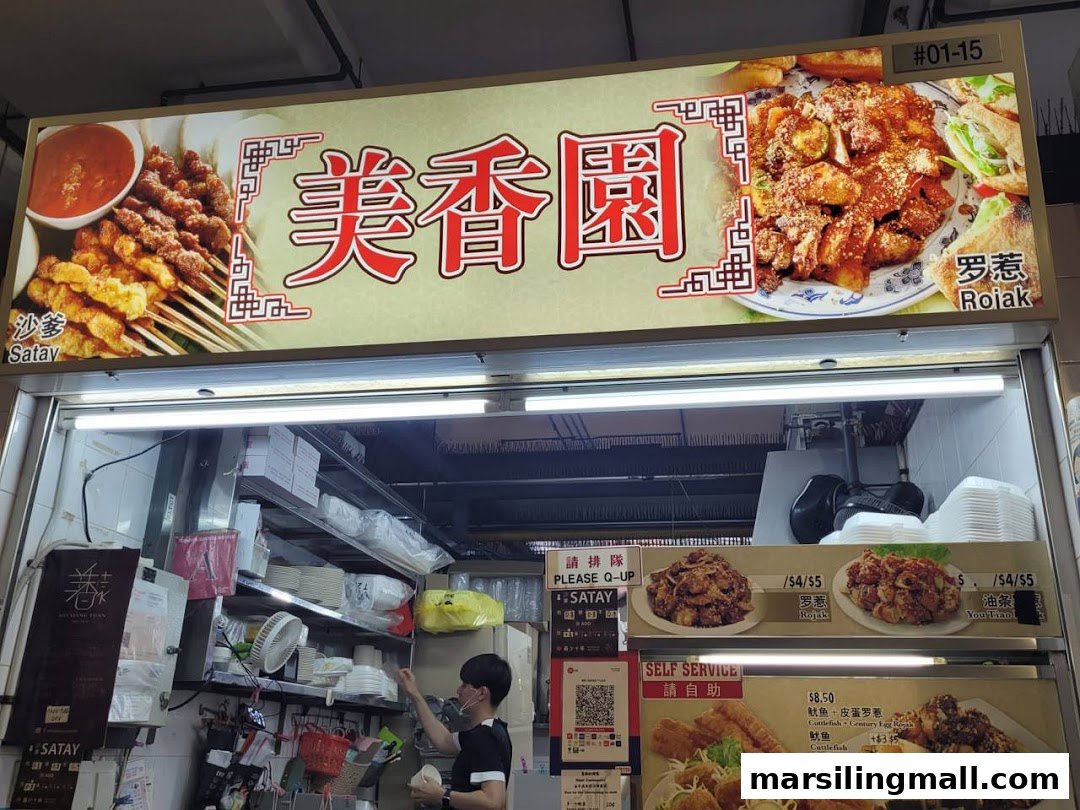 A hawker stall named Mei Xiang Yuan Satay Rojak, featuring its signboard and counter area.