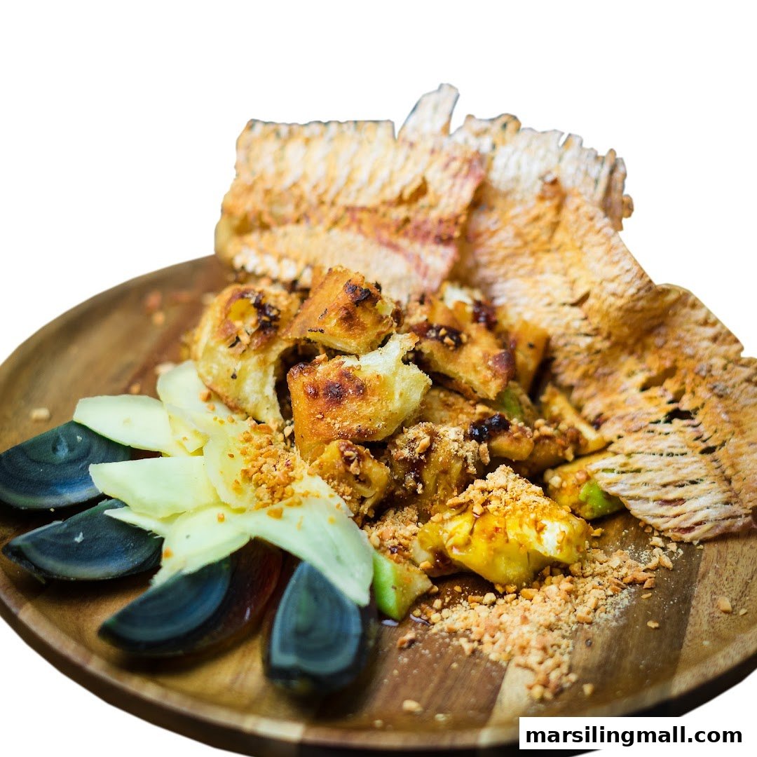 A close-up of a delicious plate of rojak with century egg, fruits, fried dough, and crushed peanuts.