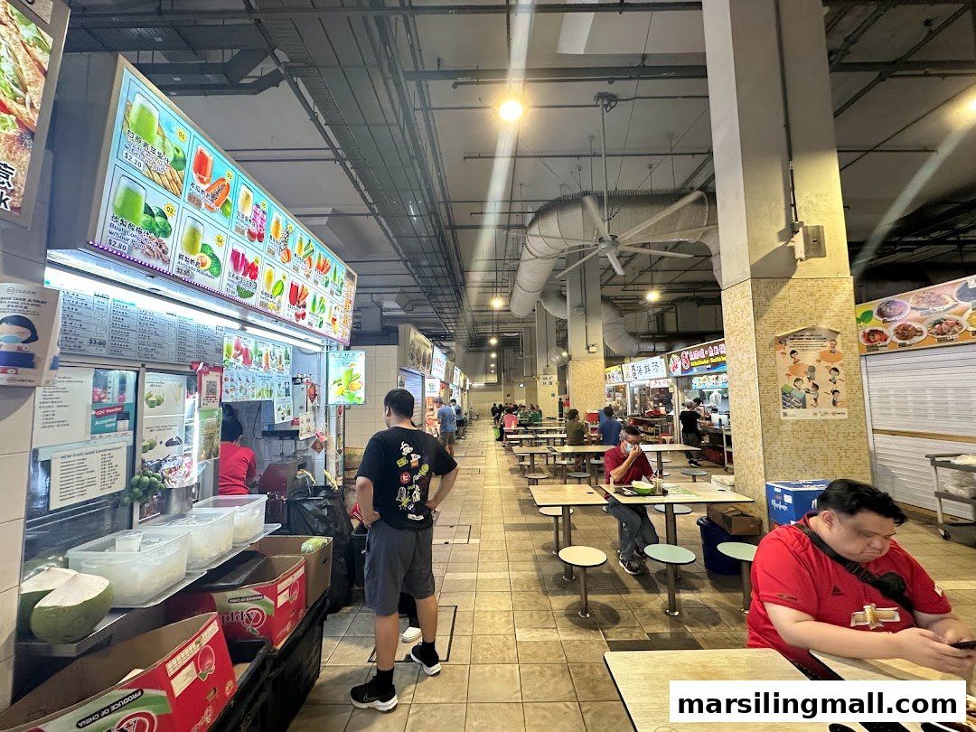 A vibrant juice stall in a bustling food court, showcasing a wide array of refreshing fruit drinks.