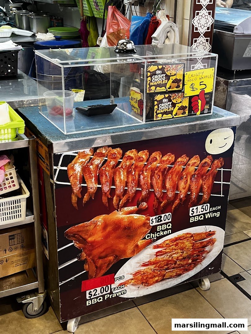 A food stall display featuring BBQ chicken, wings, prawns, and crispy chocolate waffles with prices.