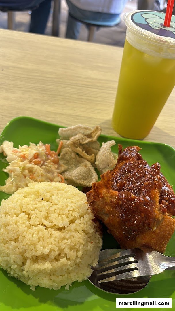 A vibrant green plate holds a delicious meal of rice, chili chicken, coleslaw, and crackers, with a refreshing drink.