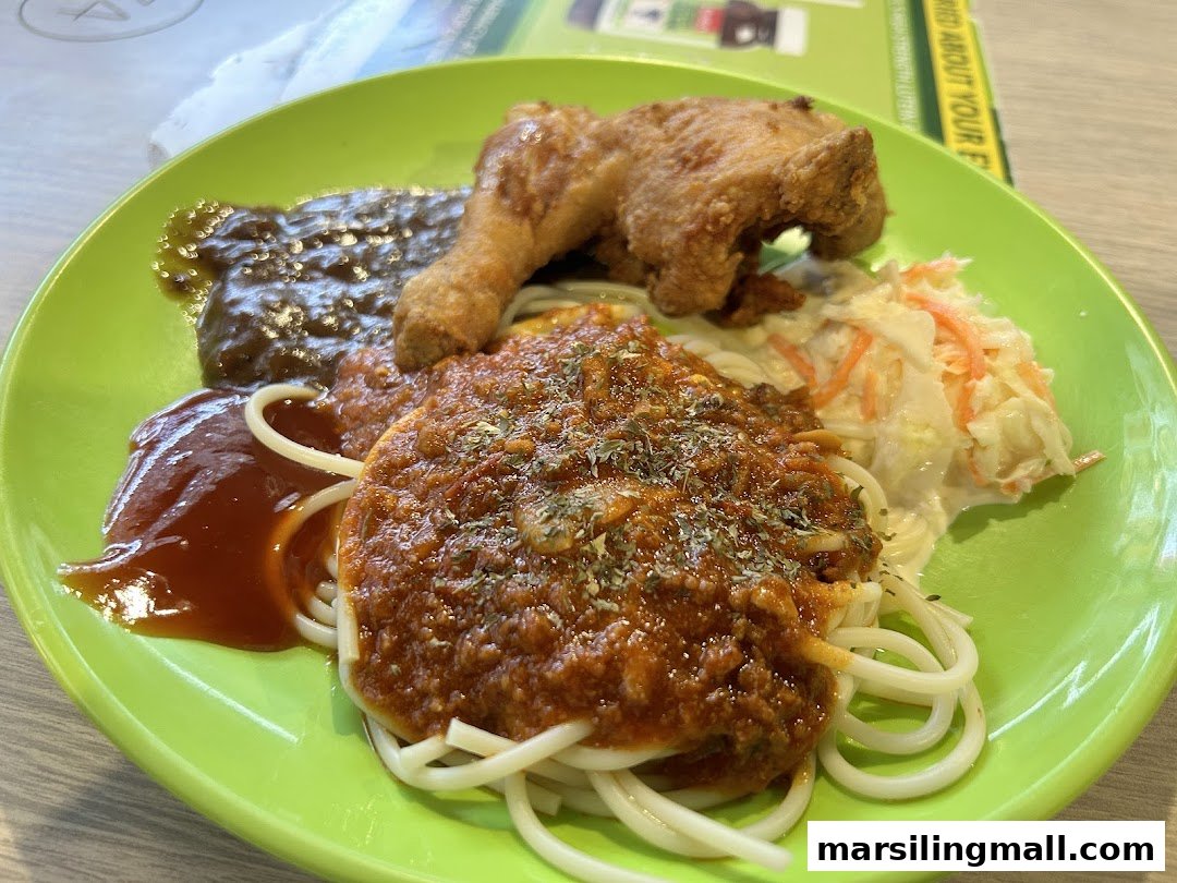 A vibrant green plate featuring spaghetti with bolognese, crispy fried chicken, coleslaw, and sauces.