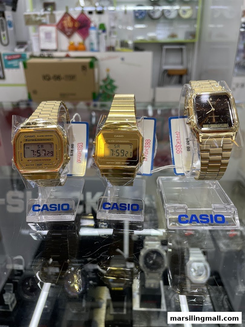 Close-up of three gold-toned Casio watches displayed in a retail shop.