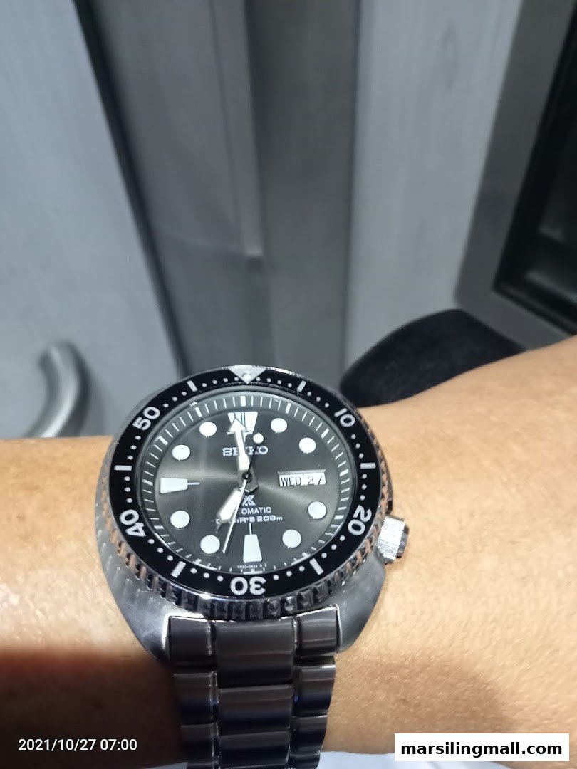 A close-up view of a stylish Seiko automatic dive watch worn on a wrist.
