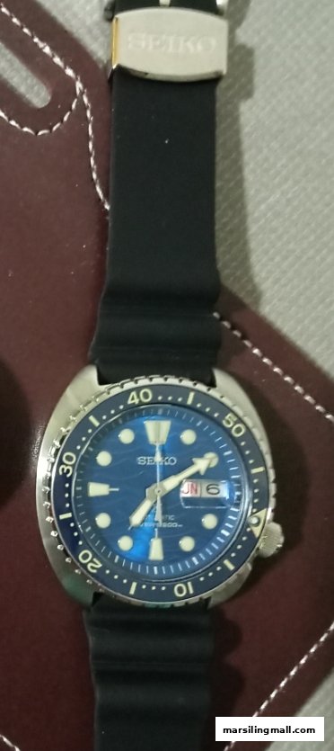 Close-up of a blue-dial Seiko automatic dive watch with a black rubber strap.