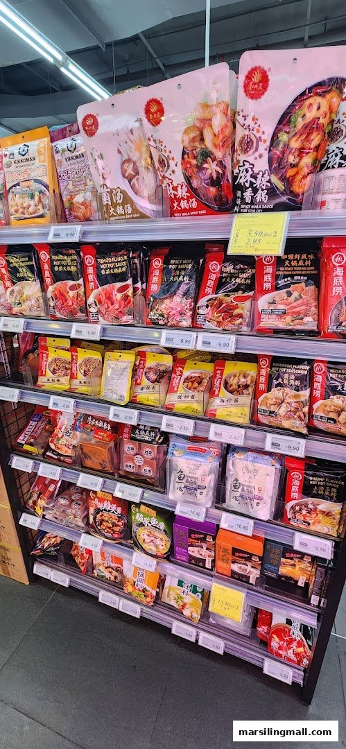 An aisle in Sheng Siong Supermarket displaying a variety of packaged hot pot bases and Asian sauces.