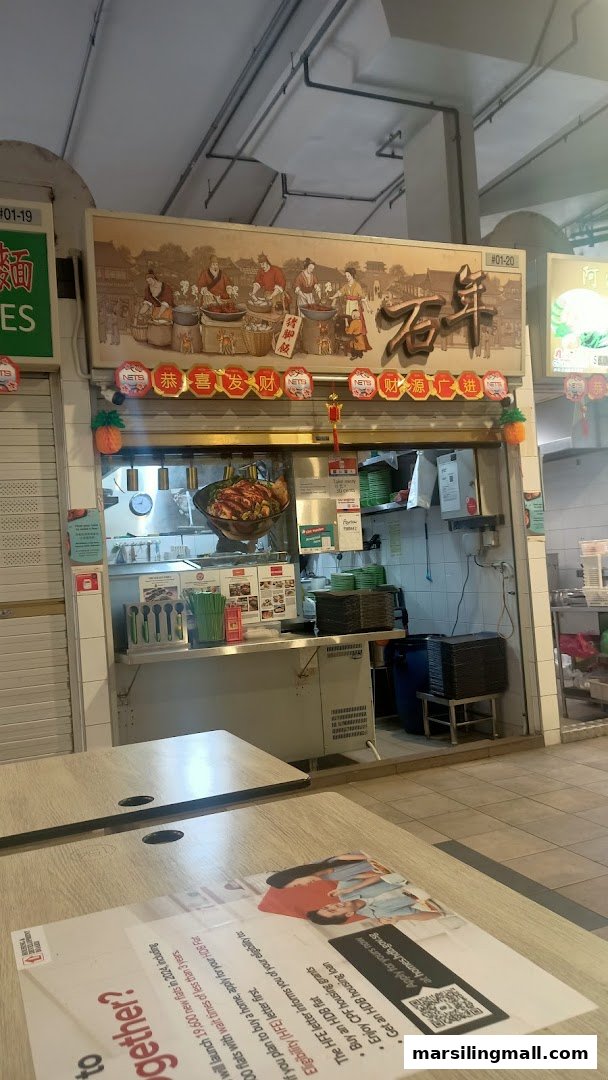 A traditional Chinese food stall counter with a decorative signboard and customer seating area.
