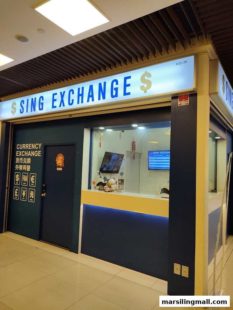 The image displays the brightly lit storefront of Sing Exchange, a currency exchange service, with its blue and yellow facade.
