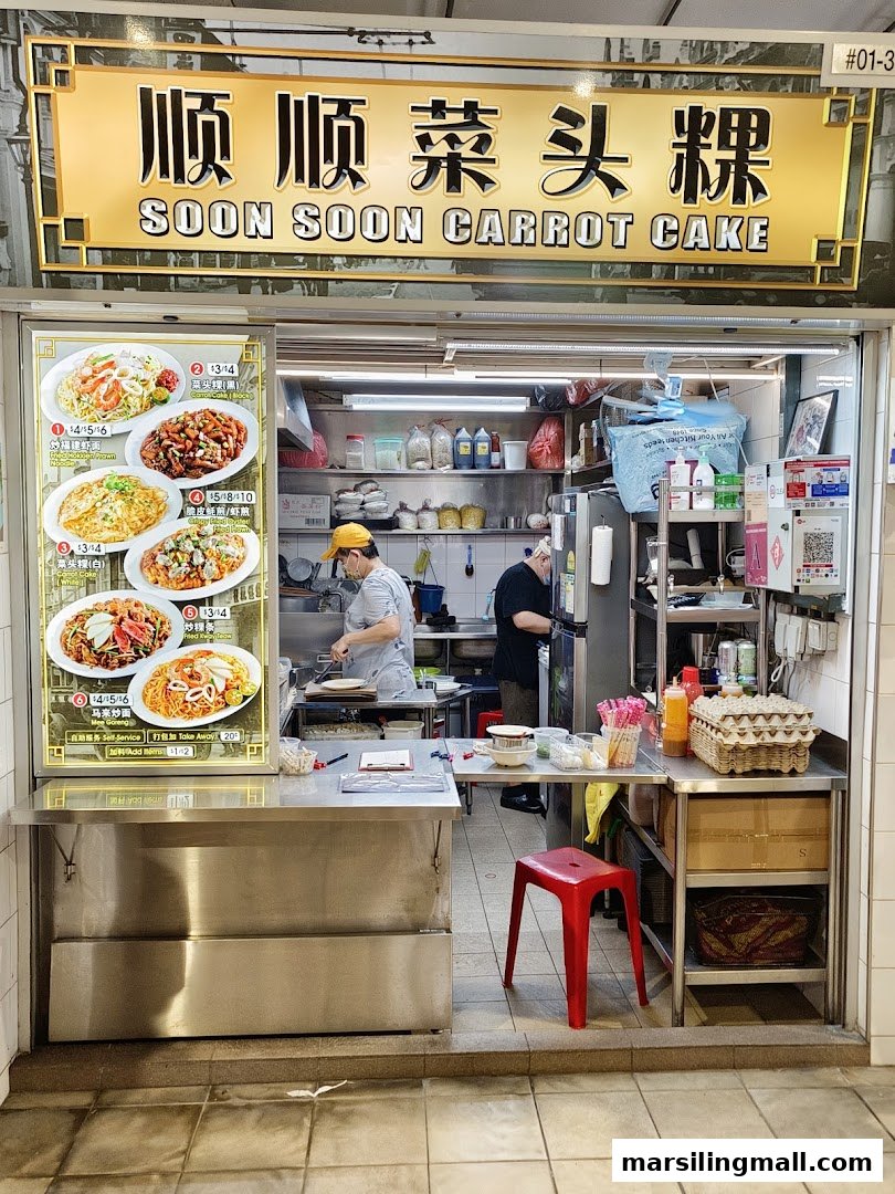 The front of Soon Soon Carrot Cake stall, showing chefs at work and a menu display.