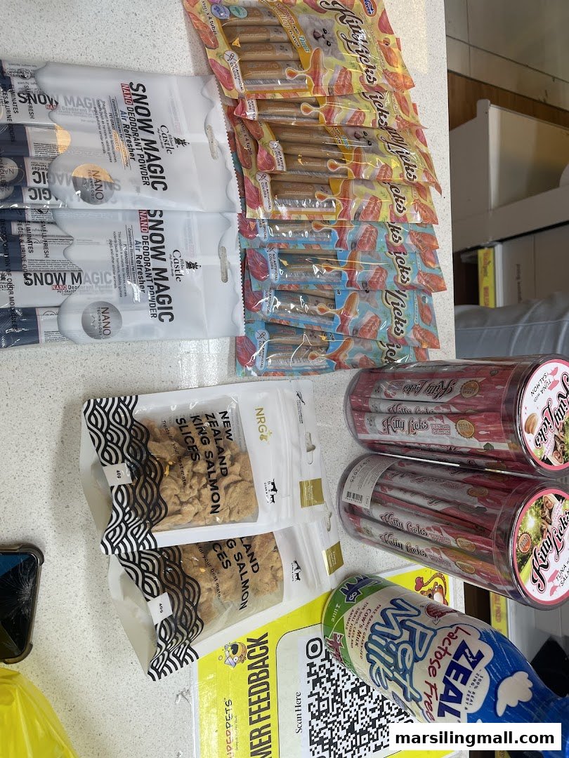 Various pet products including treats, deodorizer, and lactose-free milk displayed on a counter.
