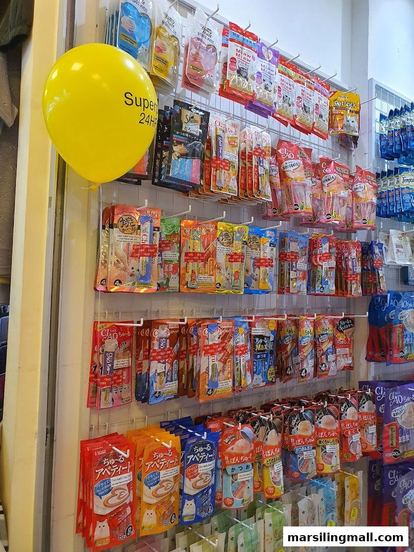 Shelves filled with various packaged pet treats and food, predominantly for cats, inside Superpets Marsiling Mall.