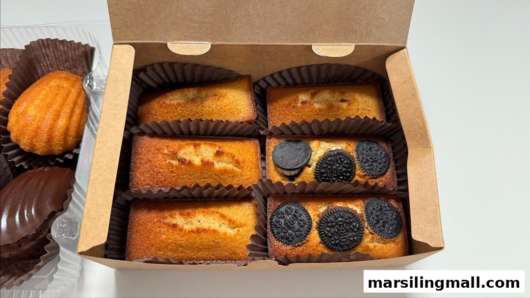 A box of mini cakes, some with Oreo toppings, and classic madeleines from The Bakehouse.