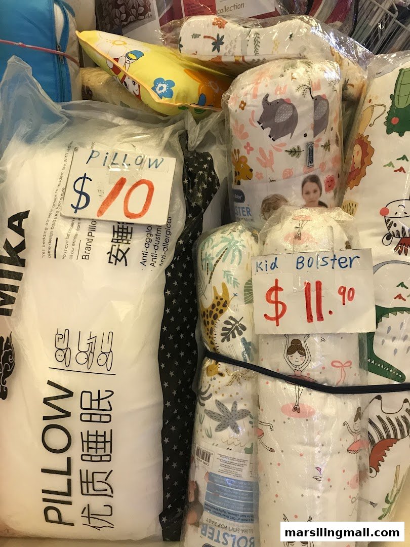 A display of various pillows and kid bolsters, some with prices, available at Ting Jia.