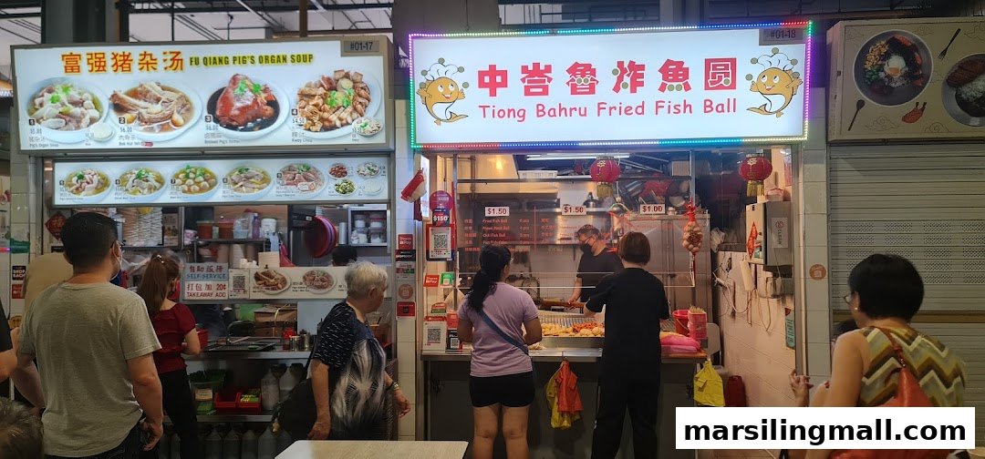 Customers queueing at the Tiong Bahru Fried Fish Ball stall in a bustling hawker centre.