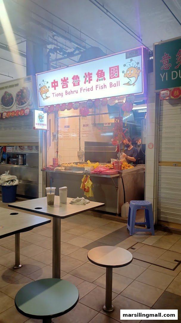 Front view of Tiong Bahru Fried Fish Ball stall with staff preparing food and outdoor seating.