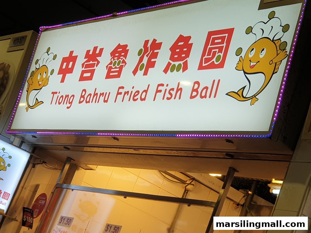 Illuminated sign for Tiong Bahru Fried Fish Ball stall with a cartoon fish mascot.